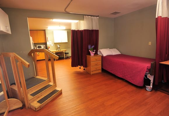 Interior view of a private resident room with bed and furniture