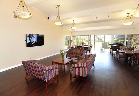 Bright common area with seating and a piano