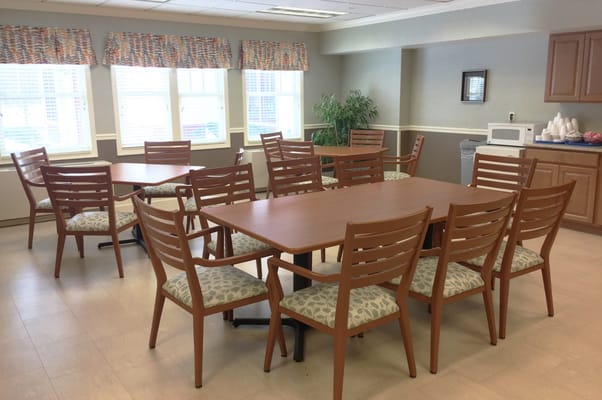Bright common area with tables and chairs for residents