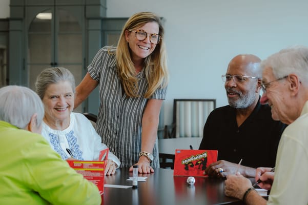 Residents and staff playing a game in an activity room
