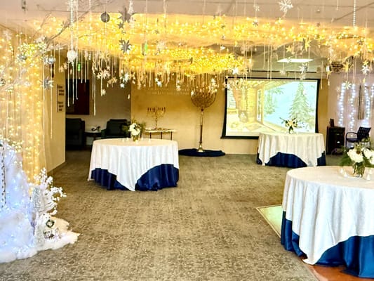 Decorated event space with festive lighting and tables