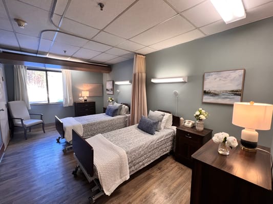 Two twin beds in a shared room with a window and bedside tables