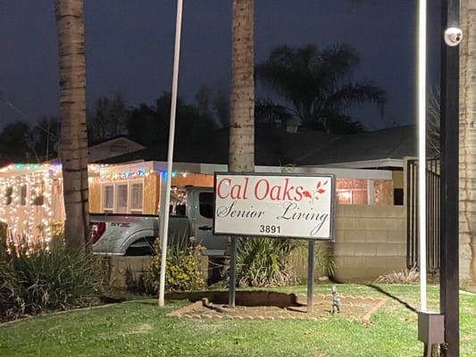 Sign for Cal Oaks Senior Living illuminated at night.