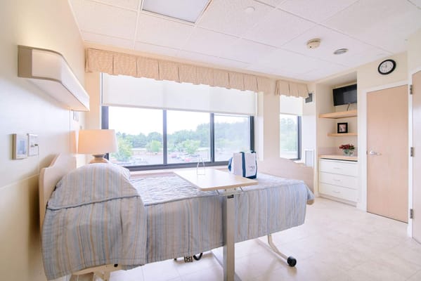A resident room with a bed and window view
