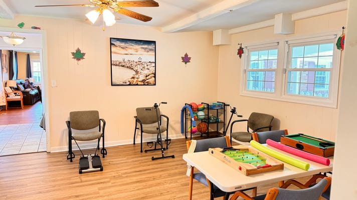 Bright common area with seating and games at CareVilla Blue Spruce