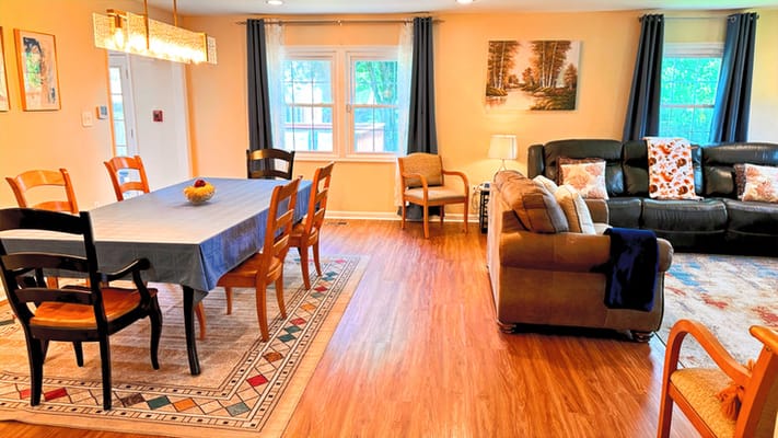 Bright living area with dining table and seating in CareVilla Blue Spruce.