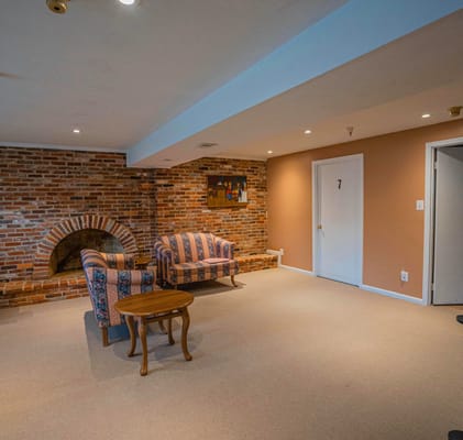 Living room with patterned sofas, brick wall, and artwork