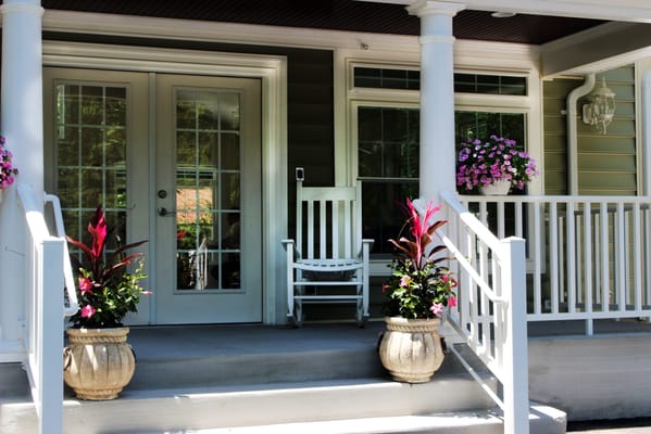 Front porch of Clifton Woods Memory Care Home with decorative plants