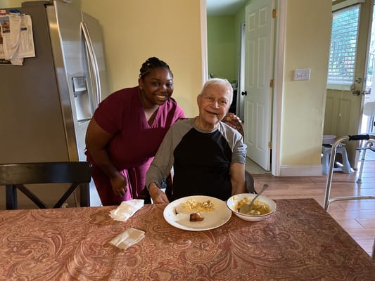 A caregiver and resident enjoying a meal together