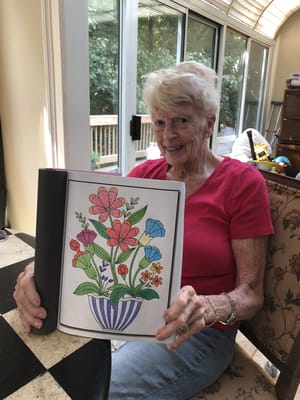 Senior resident coloring flowers in a cheerful activity room