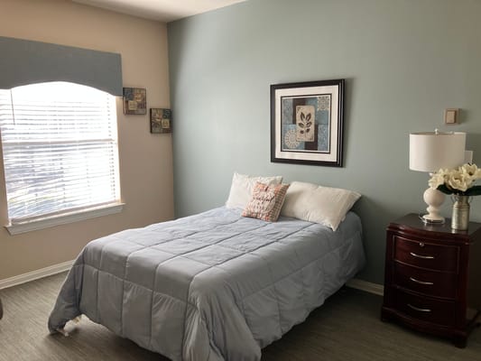 Brightly decorated private room with a bed and window