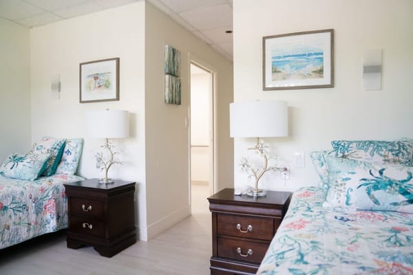 A bright and inviting bedroom suite with two beds and decorative elements.