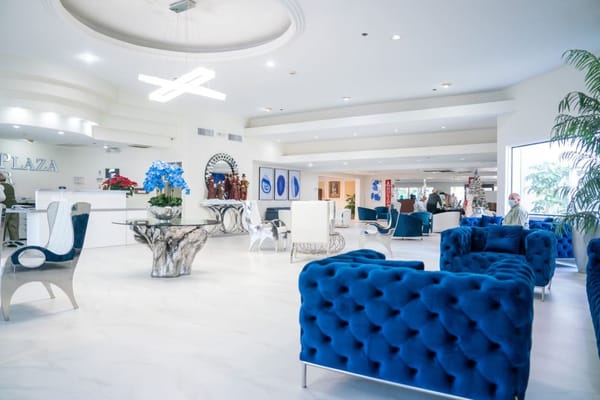 Welcoming lobby with blue tufted chairs and modern decor at Coral Plaza