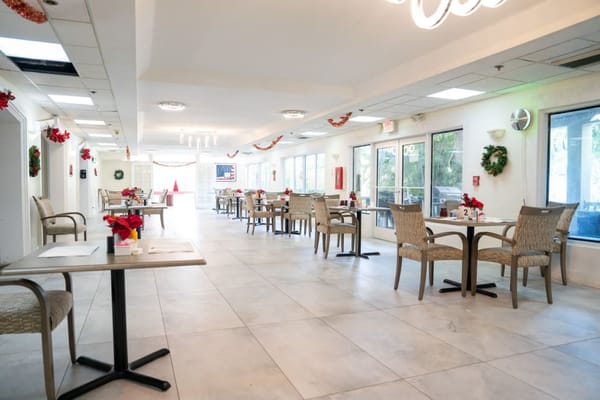 Bright dining area decorated for the holidays, featuring tables and chairs