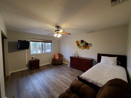 Bright private resident room with a bed and seating area