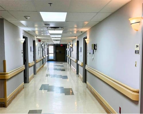 A well-lit hallway with resident rooms