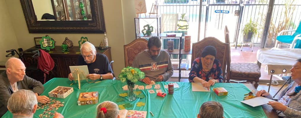 Seniors enjoying games at a table with a green tablecloth.