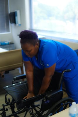 Staff member adjusting a wheelchair in the facility