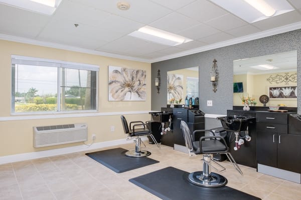 Hair salon area with two styling chairs in a bright room