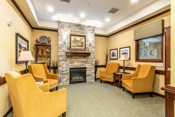 Inviting living room with orange chairs and a stone fireplace