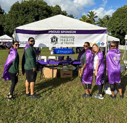 Team members in purple capes at an outdoor event