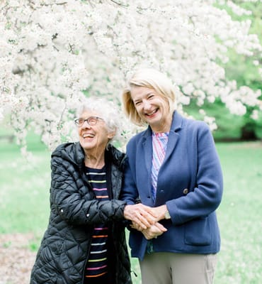 Happy resident and staff member enjoying spring flowers