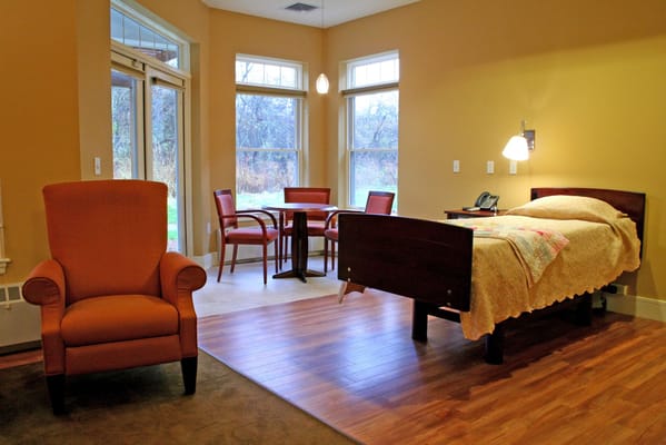 A private resident room with an armchair and bed
