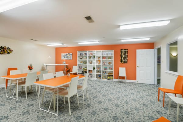 Bright activity room with orange decor and seating