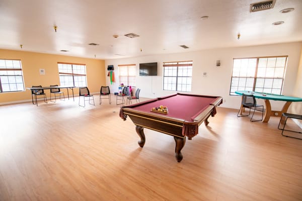 Bright common area with a billiards table and seating