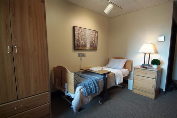 A well-furnished private resident room with a bed and decor