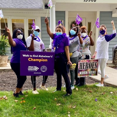 Participants holding banners and flags at an Alzheimer's awareness event.