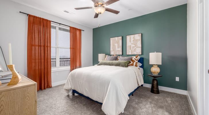 A cozy bedroom with a neatly made bed and decor