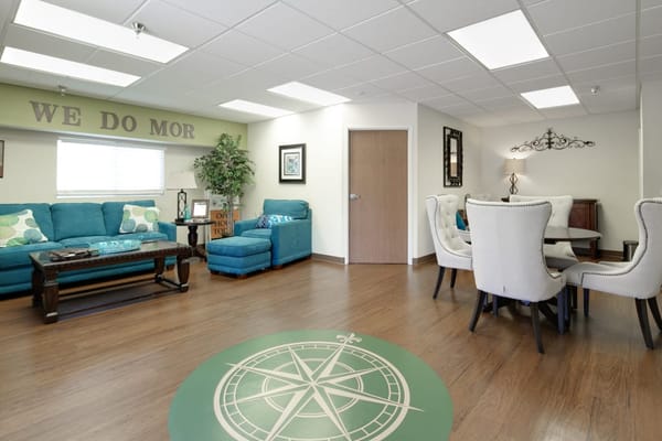 Cozy living room with teal sofas and dining area