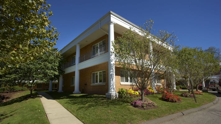 Exterior view of a senior living facility with gardens