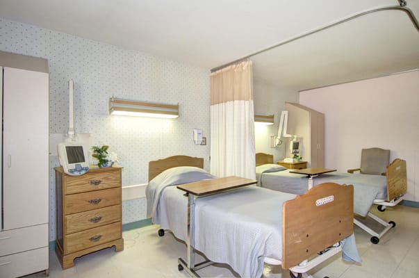 Private resident room with two beds and basic furnishings