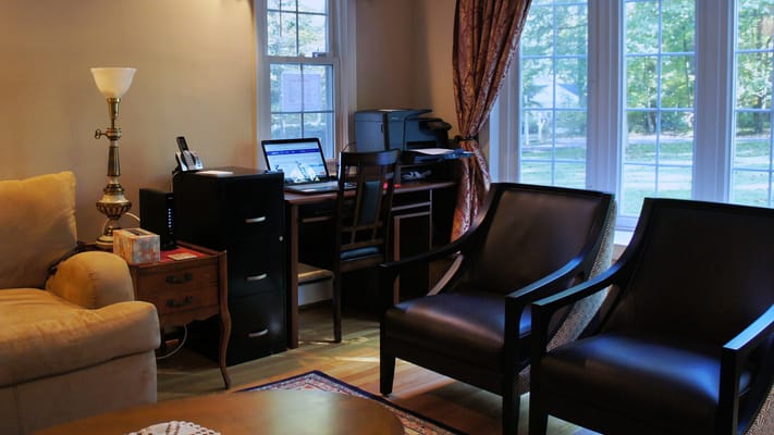 Small office area with desk, computer, and seating