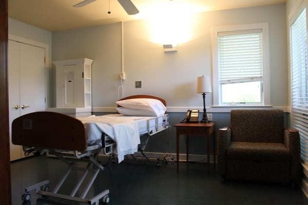 Private resident room with a bed and chair