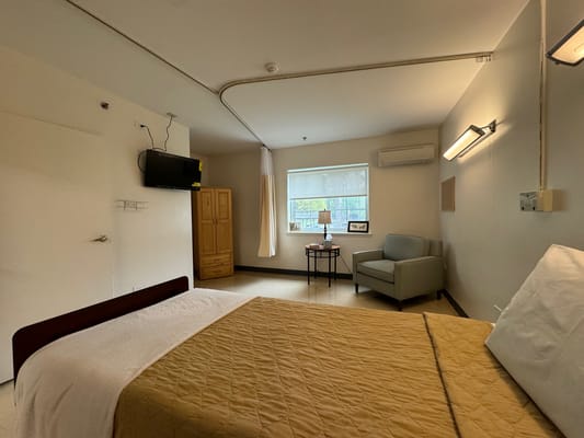 A private resident room with bed and seating area
