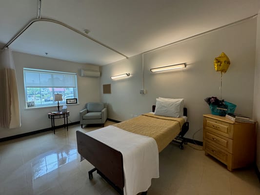 Interior view of a resident room with a bed and chair