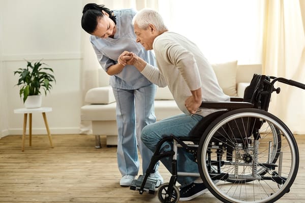 Caregiver assisting a resident in a bright interior setting