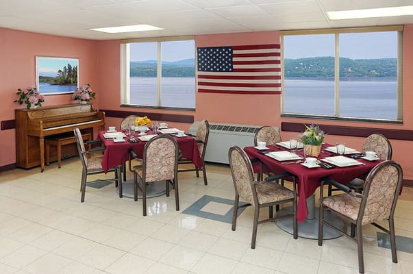 Dining room with views of the river and mountains, featuring tables set for a meal