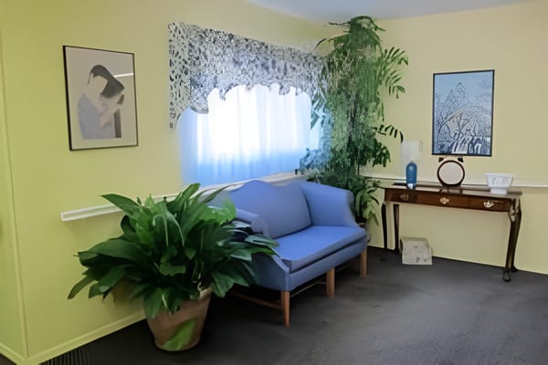 Living area with blue sofa, plants, and wall art