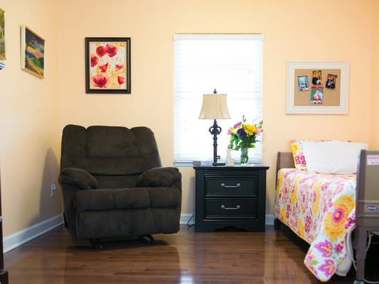 Cozy bedroom with floral decor and a recliner