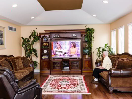 Resident watching television in a cozy common area