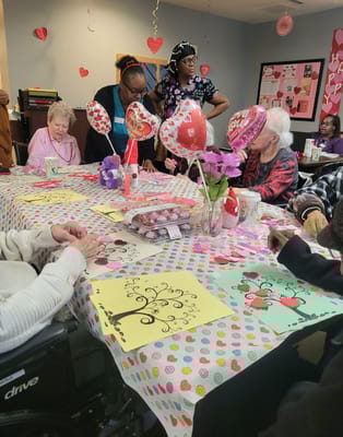 Residents and staff celebrating an event at a decorated table