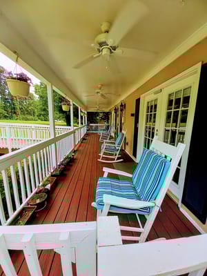 Outdoor porch with rocking chairs and potted flowers