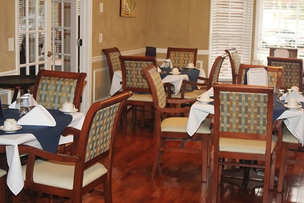 Dining area with wooden chairs and tables set for a meal
