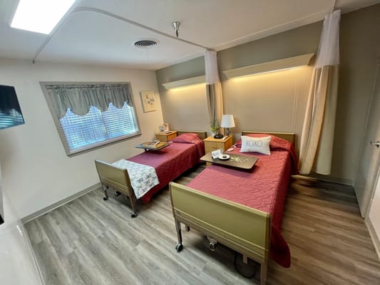 A shared resident room with two beds and decor