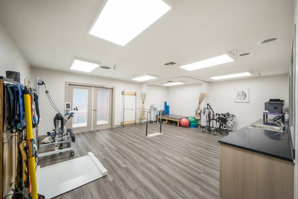 A bright therapy room with exercise equipment