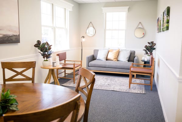 Cozy living room with a gray couch and wooden chairs